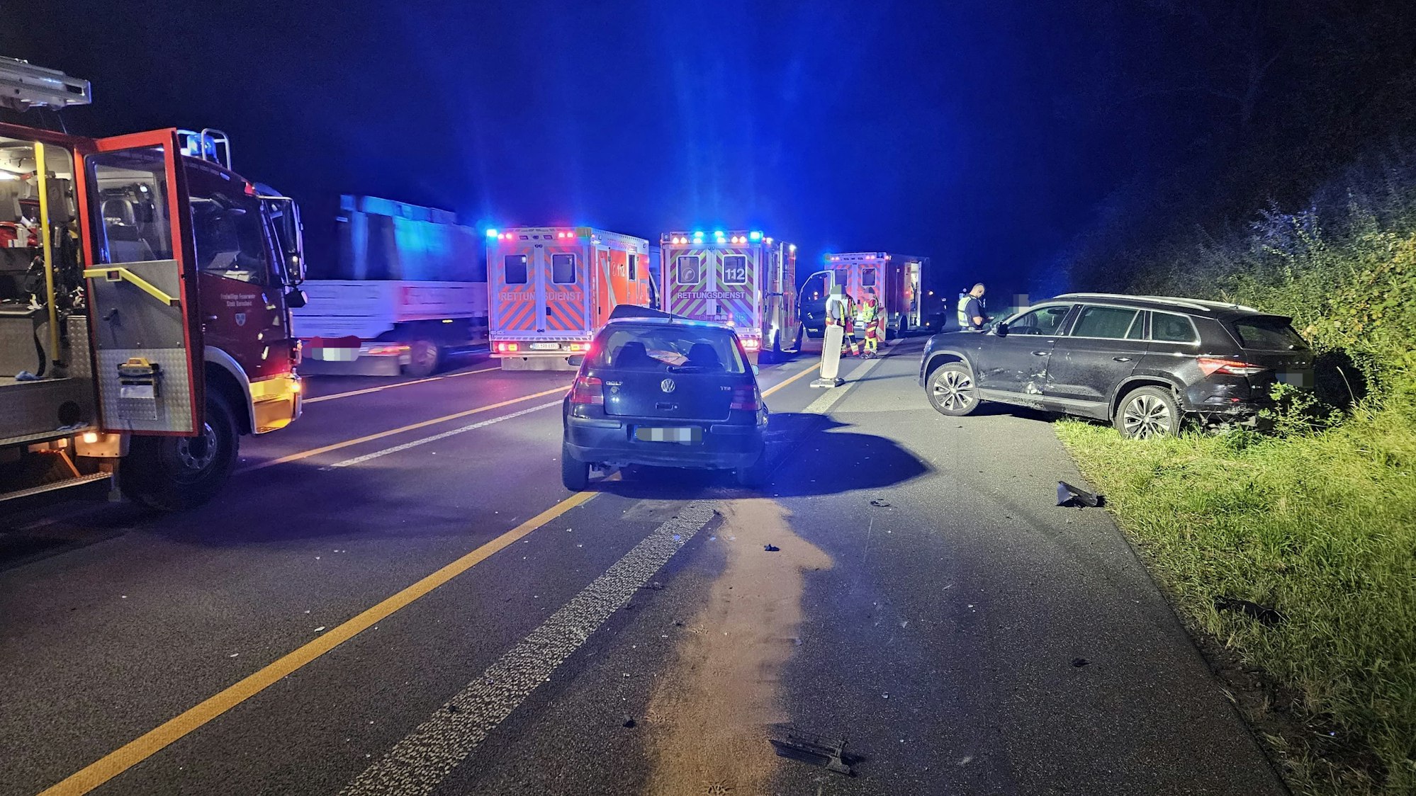 Zwei Autos stehen nachts nach einem Unfall auf einer Autobahn.