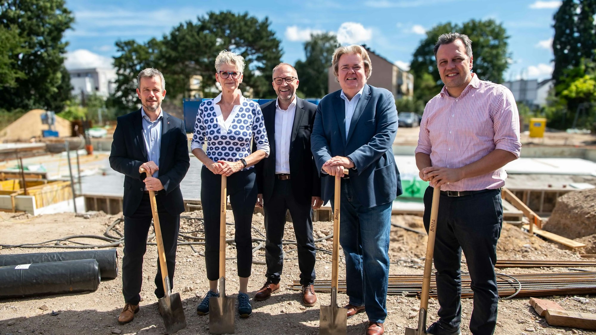 Das Bild zeigt Vertreter der Stadt, der Caritas und des Bauherrn mit einem Spaten in der Hand.