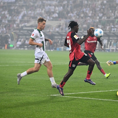 Jeremie Frimpong von Bayer Leverkusen und Mönchengladbachs Torhüter Jonas Omlin in Aktion.