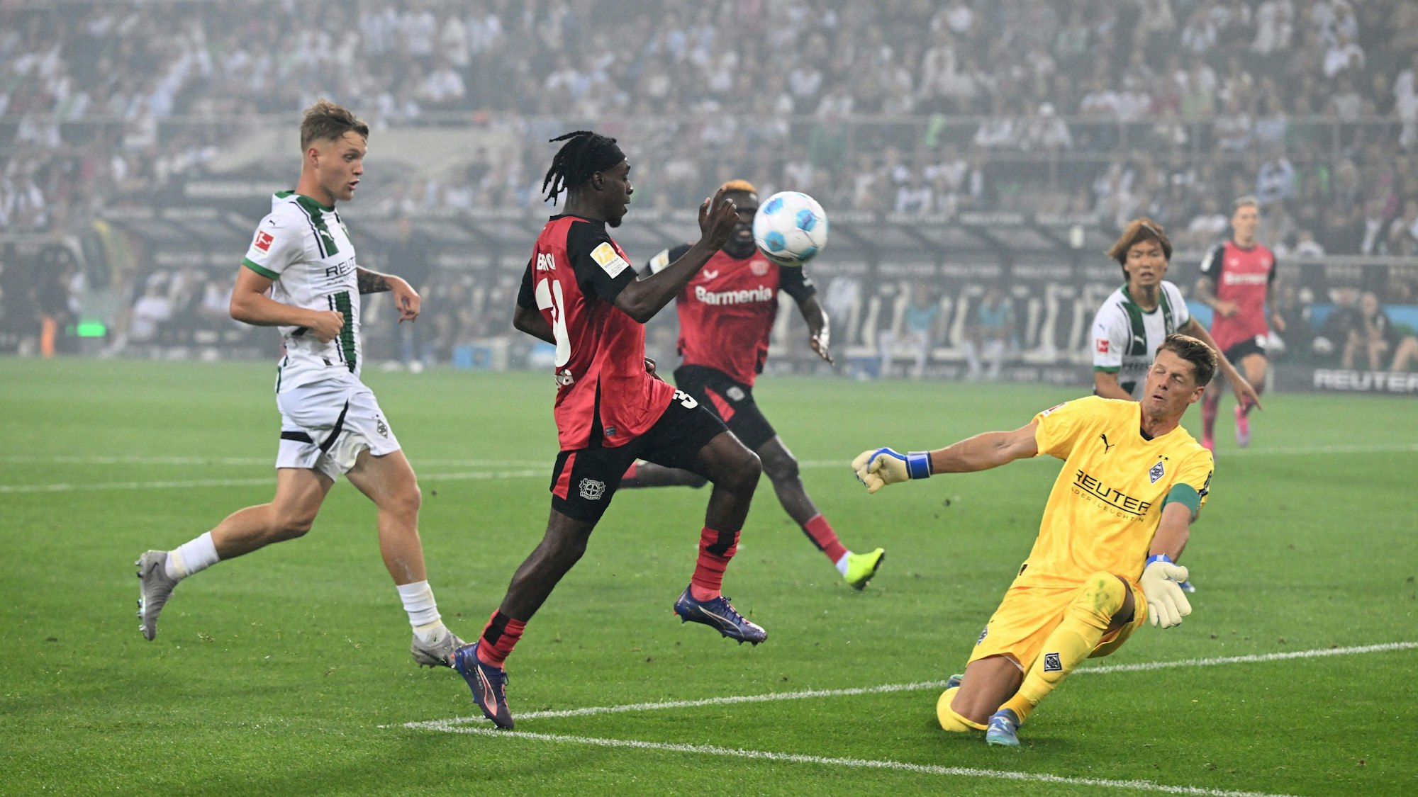 Jeremie Frimpong von Bayer Leverkusen und Mönchengladbachs Torhüter Jonas Omlin in Aktion.
