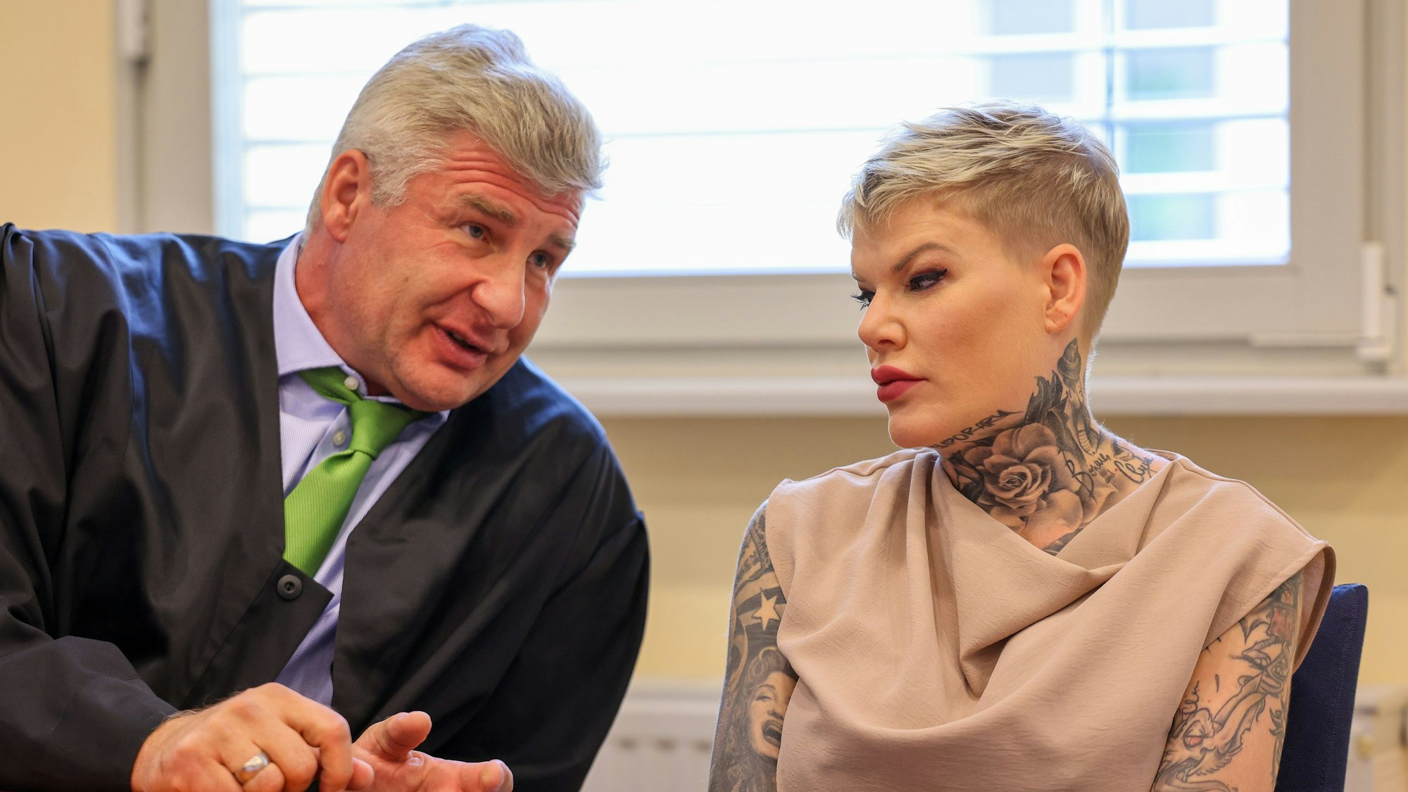 Melanie Müller und ihr Anwalt Adrian Stahl sitzen vor Beginn der Gerichtsverhandlung im Amtsgericht Leipzig.