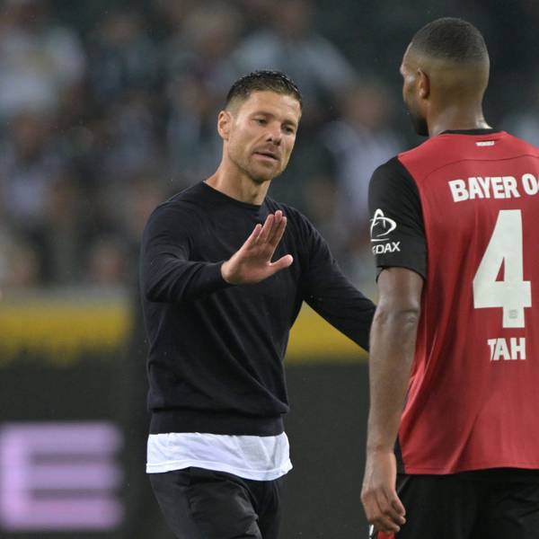 Trainer Xabi Alonso von Bayer Leverkusen schlägt nach dem Spiel mit Spieler Jonathan Tah ein.