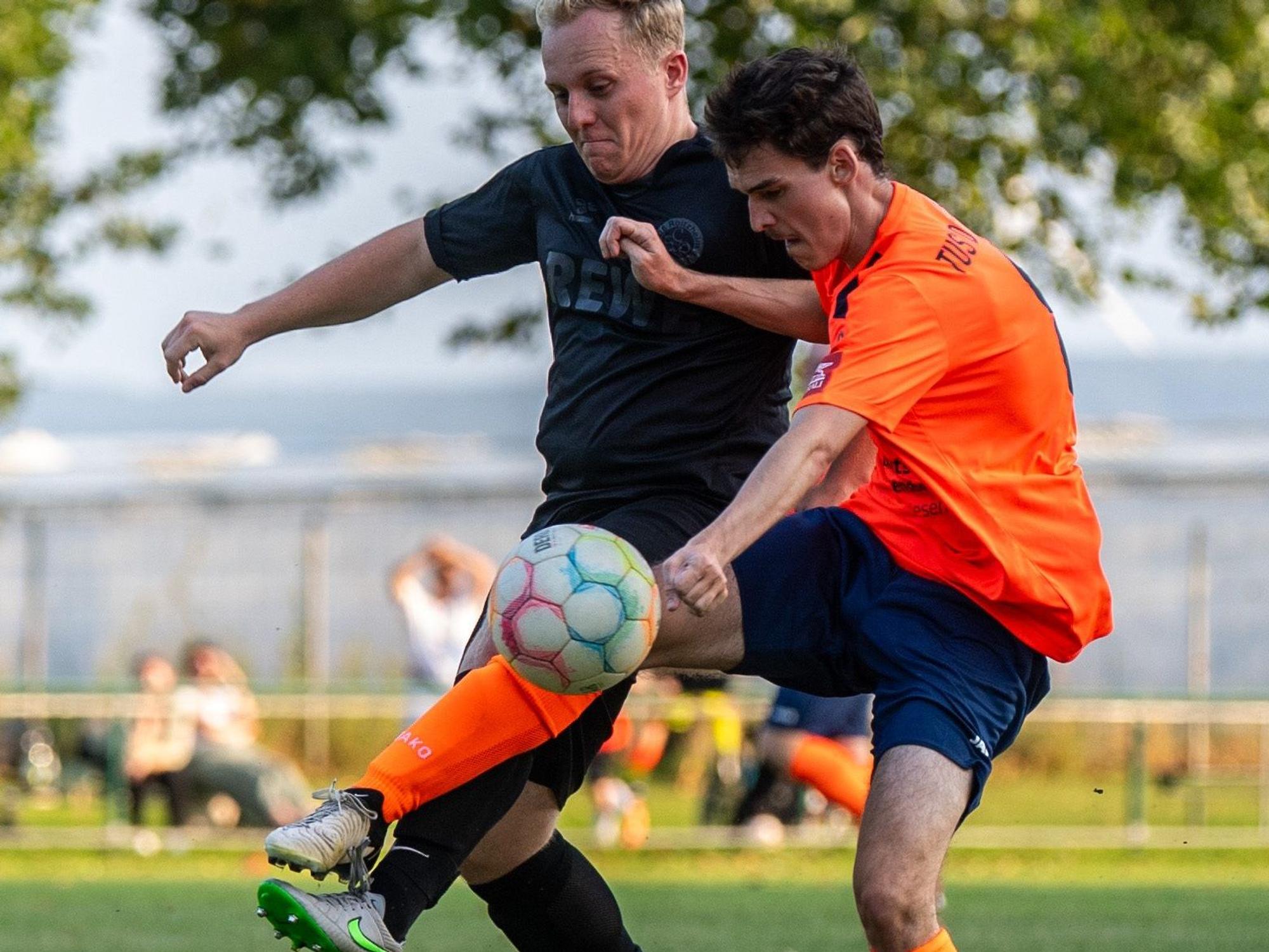 Zwei Fußballspieler im Zweikampf um den Ball.