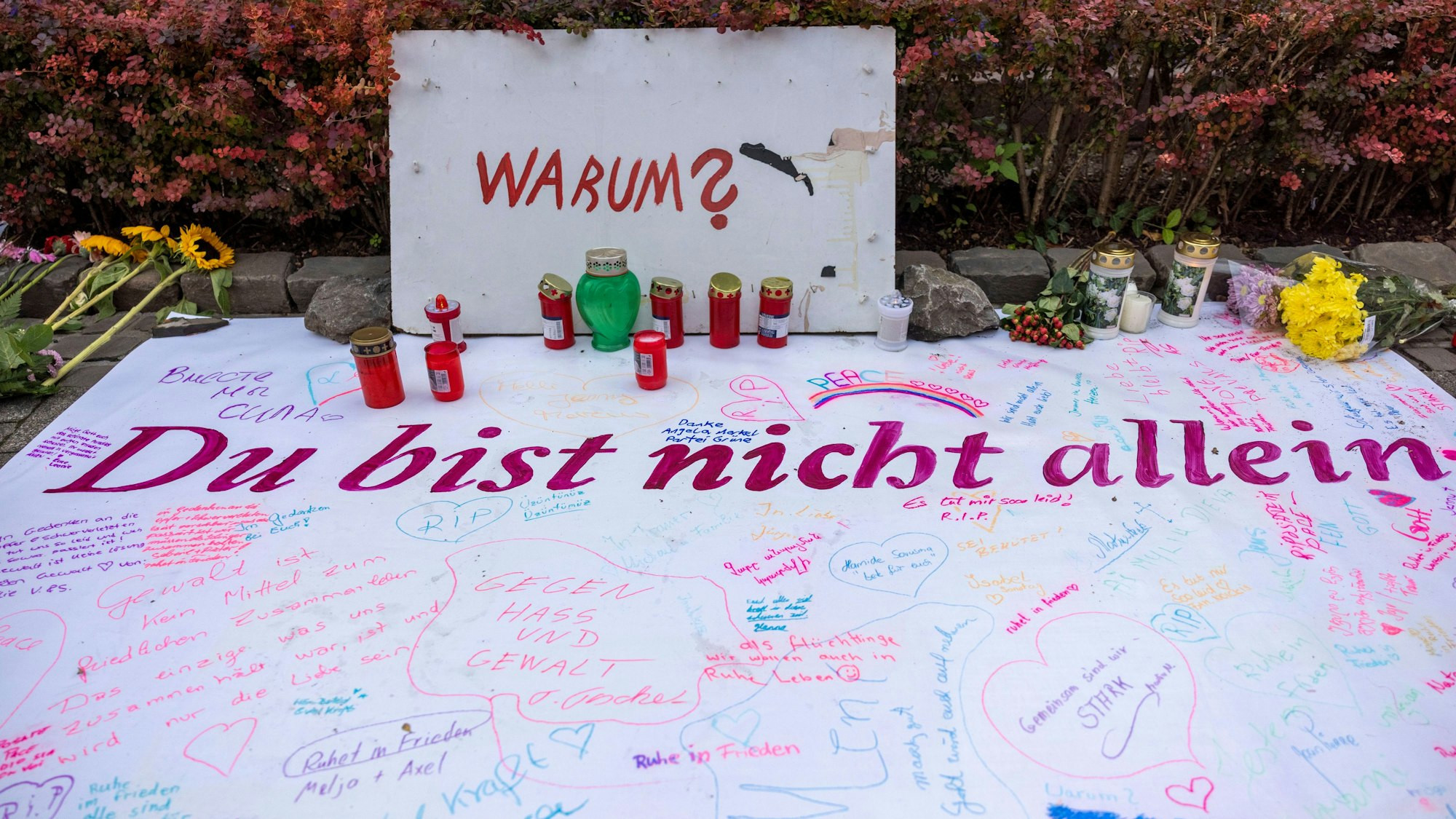 Nach der Messerattacke auf dem Solinger Stadtfest haben Menschen in der Nähe des Tatortes Nachrichten sowie Blumen und Kerzen hinterlassen.