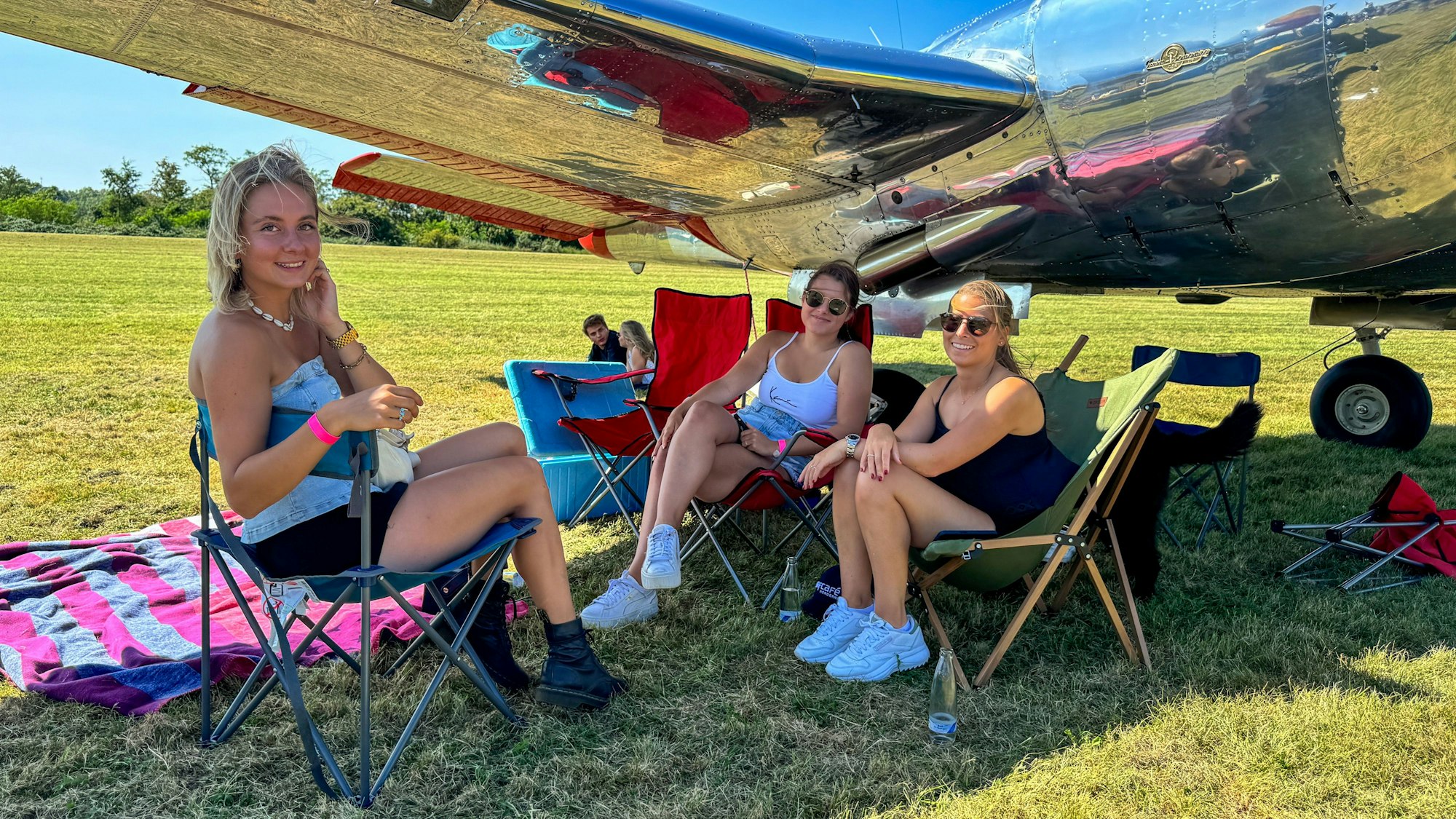 Stella Schäfers, Jil Sadlowski und Pia Sadlowski unter dem Flügel einer Beechcraft Twin Bonanza