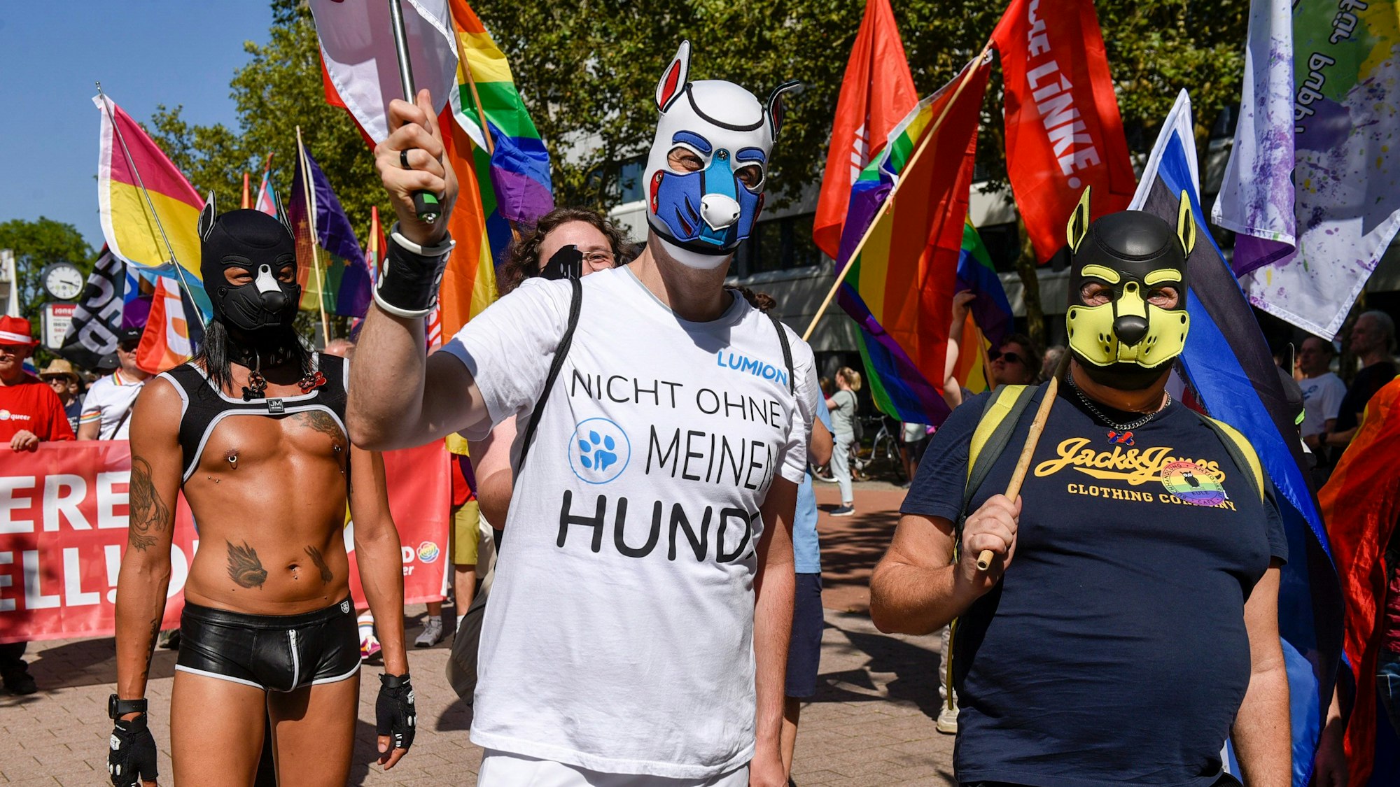 Auf dem Bild sind Zugteilnehmer mit Hundemasken zu sehen.