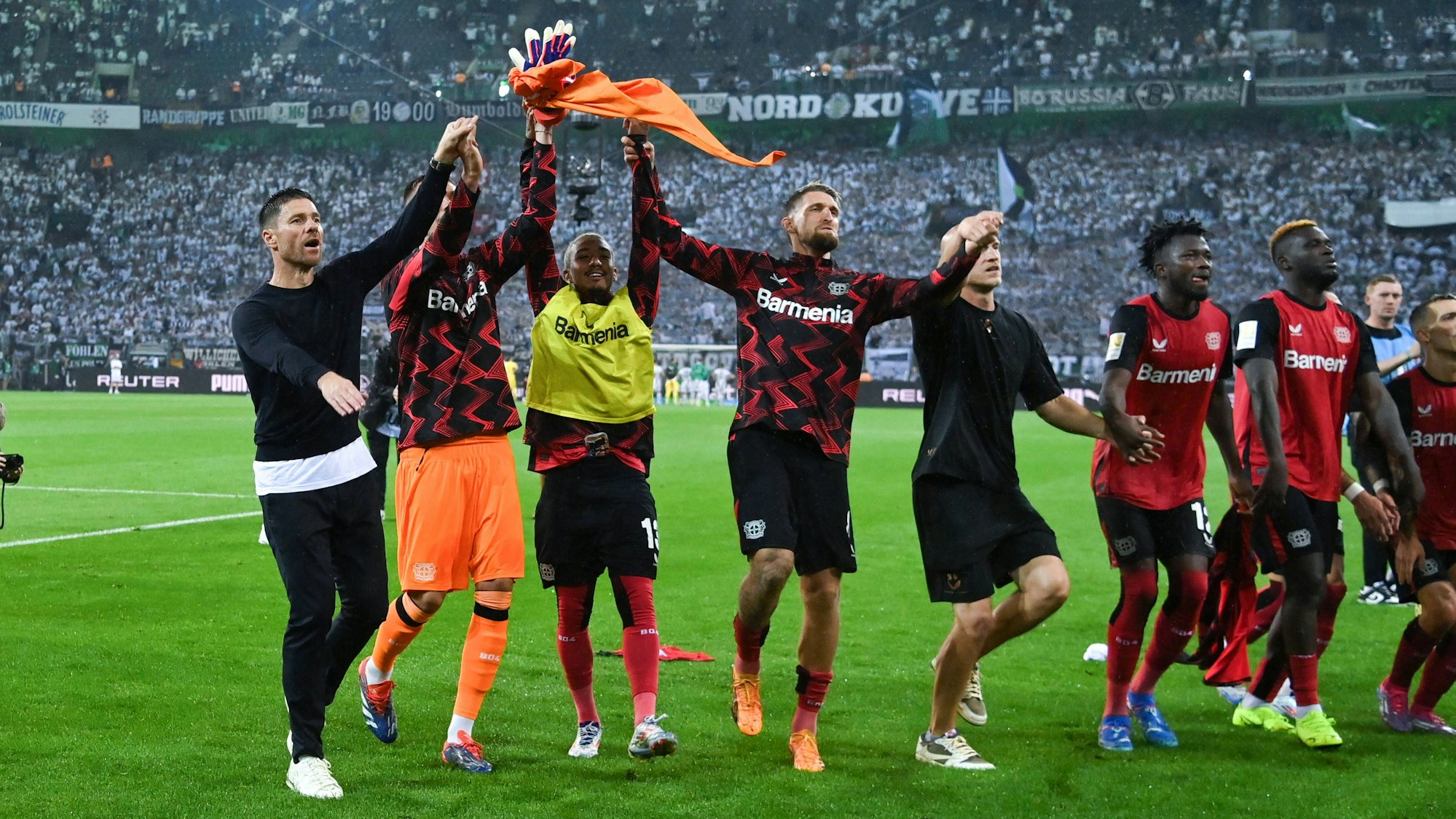 Xabi Alonso (l.) feiert mit den Leverkusener Spielern nach dem 3:2-Sieg in Mönchengladbach.