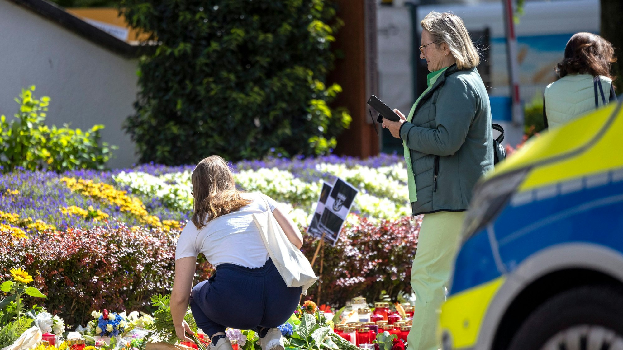 Nach der Messerattacke auf dem Solinger Stadtfest legen Menschen in der Nähe des Tatortes Blumen und Kerzen zum Gedenken der Opfer nieder.