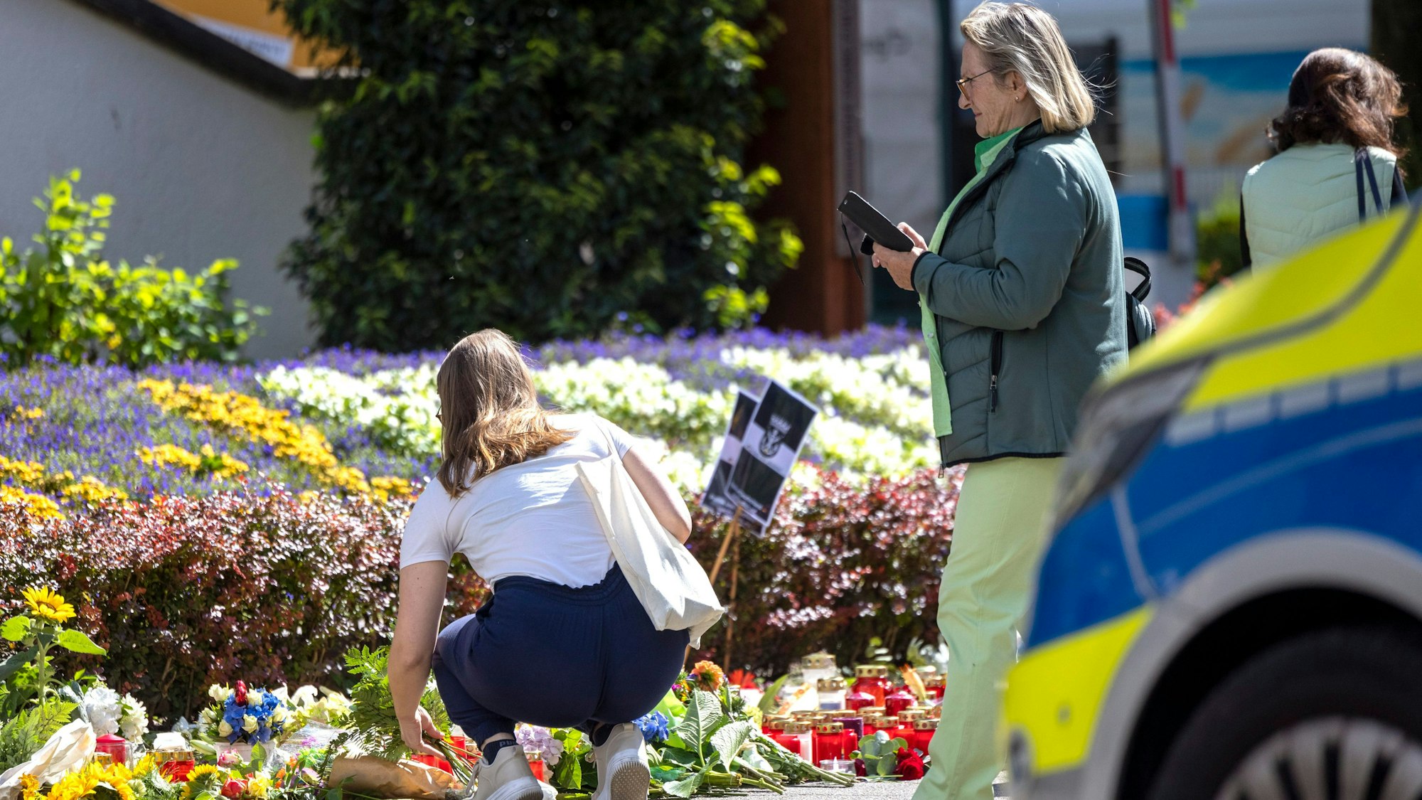 Nach der Messerattacke auf dem Solinger Stadtfest legen Menschen in der Nähe des Tatortes Blumen und Kerzen zum Gedenken der Opfer nieder.