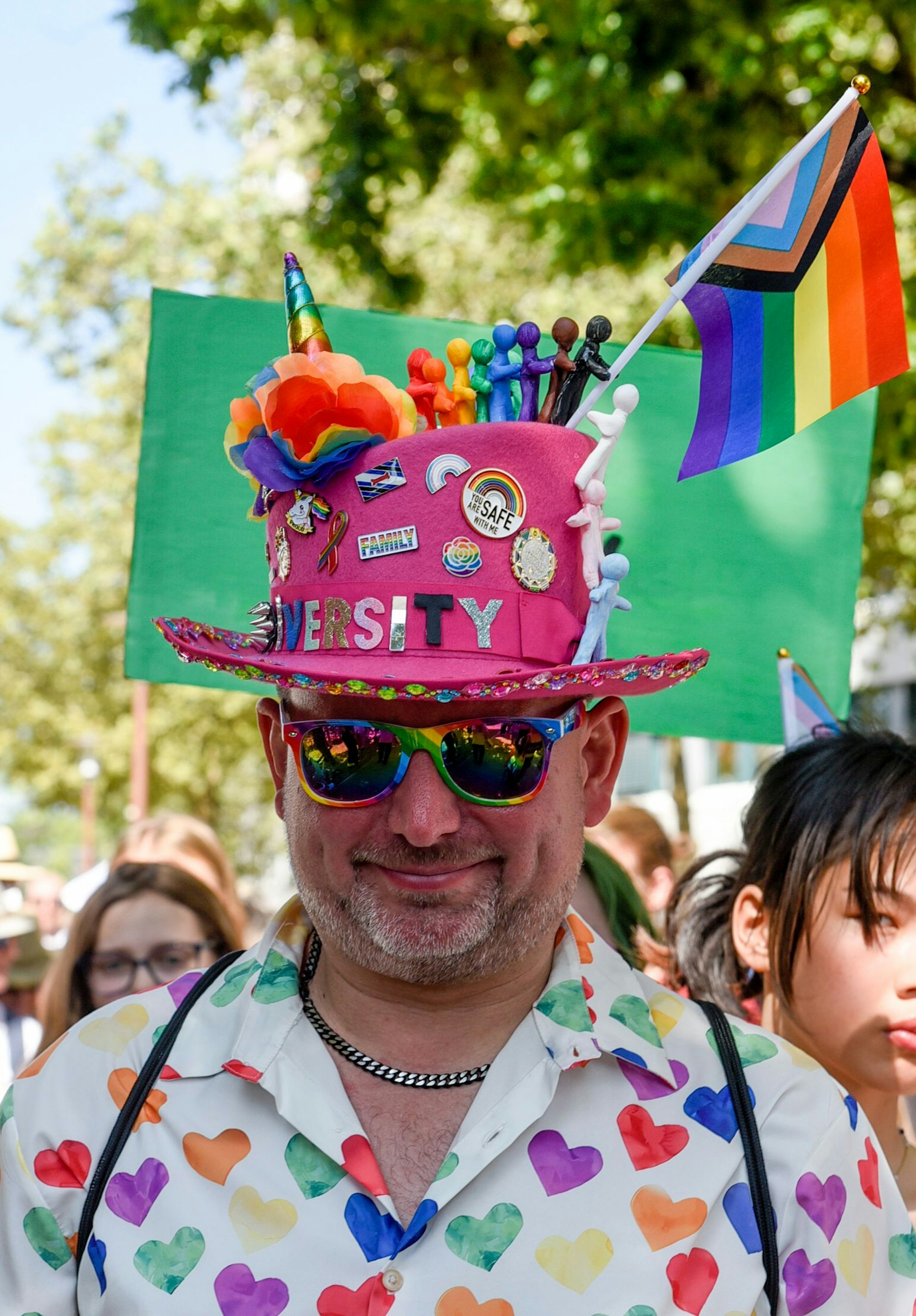 Auf dem Bild ist ein Zugteilnehmer mit einem bunten Zyinderhut zu sehen.