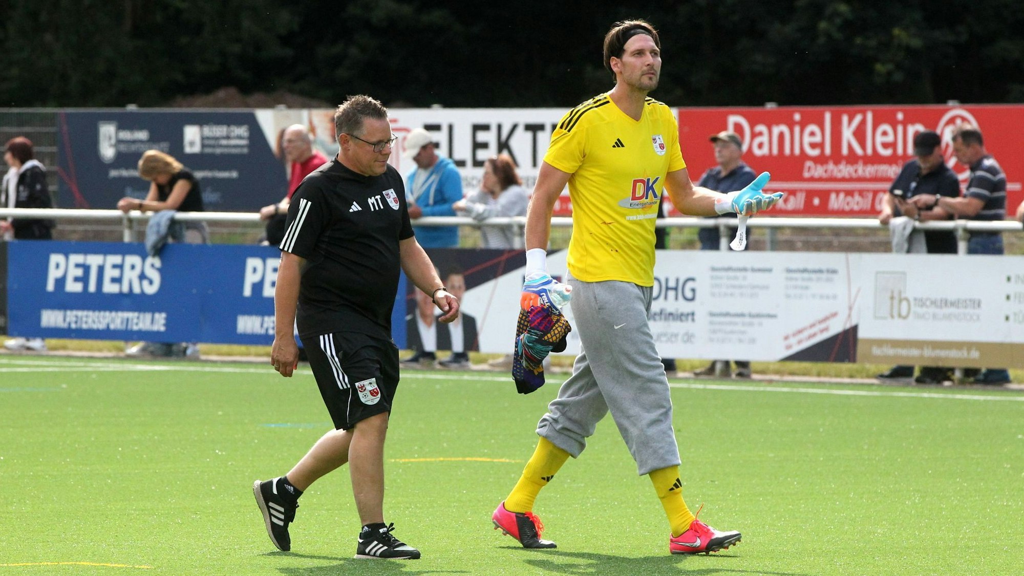 Dahlems Torwart Fabian Giefer trägt graue Schlabber-Jogginghose. Neben ihm Trainer Marcel Timm.