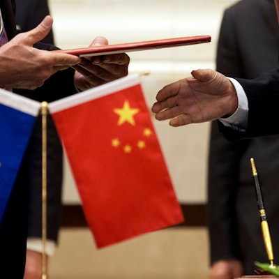 Ein Mitglied der Europäischen Kommission (l) bereitet sich auf den Austausch von Dokumenten mit der chinesischen Delegation vor.