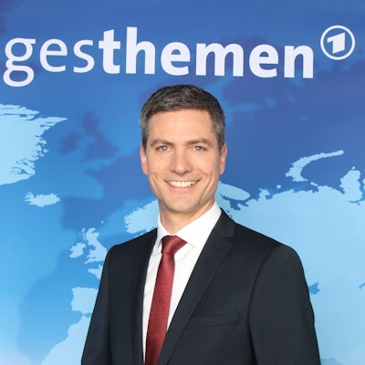 Tagesthemen-Moderator Ingo Zamperoni lacht in die Kamera.