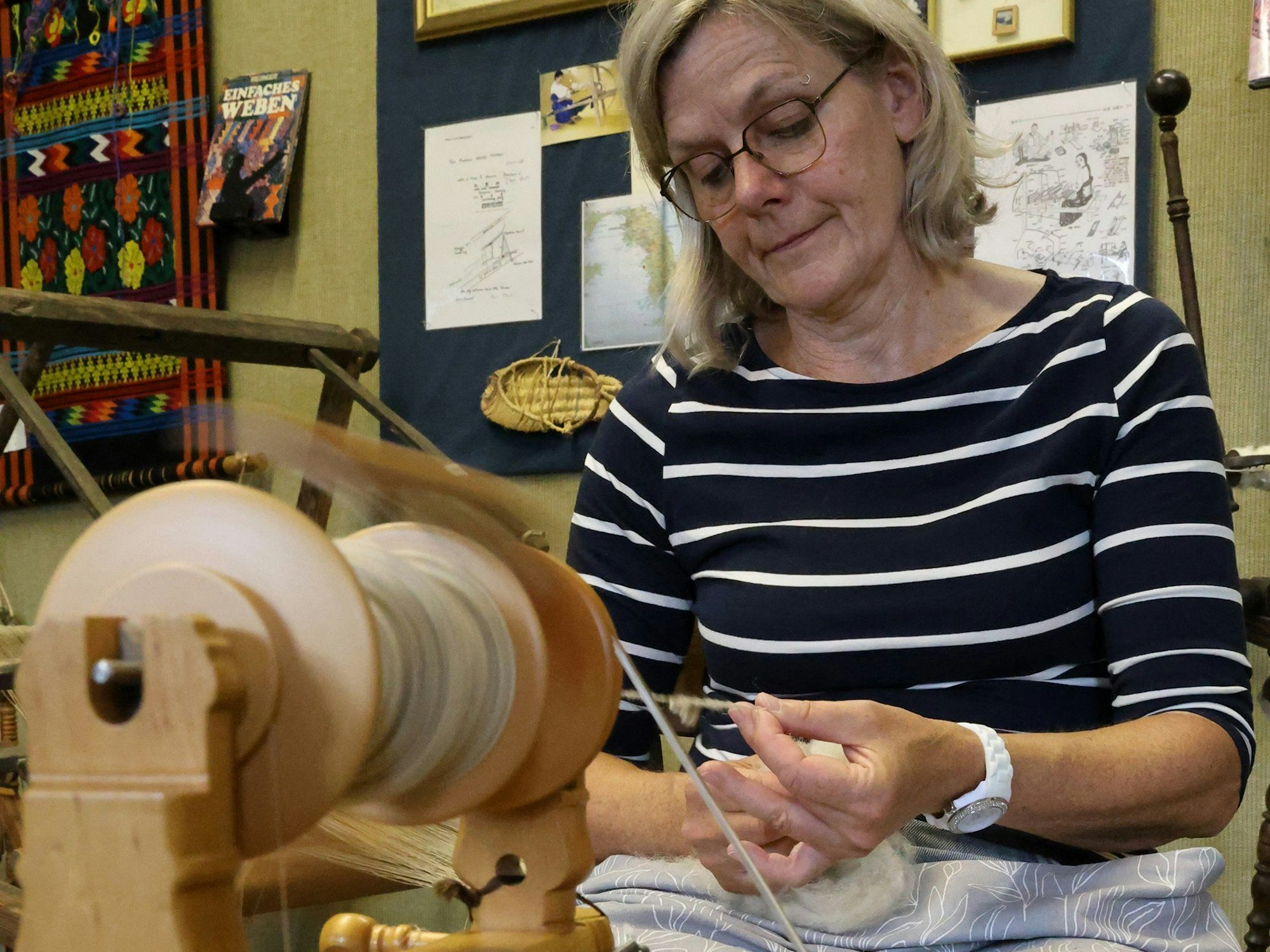 Claudia Heuser arbeitet an einem Spinnrad.