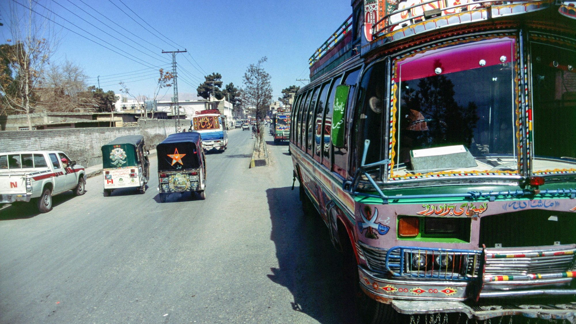 Quetta Baluchistan Pakistan 2001. Street scene with brightly coloured buses and other vehicles. Analogue image. Pakistani, street,