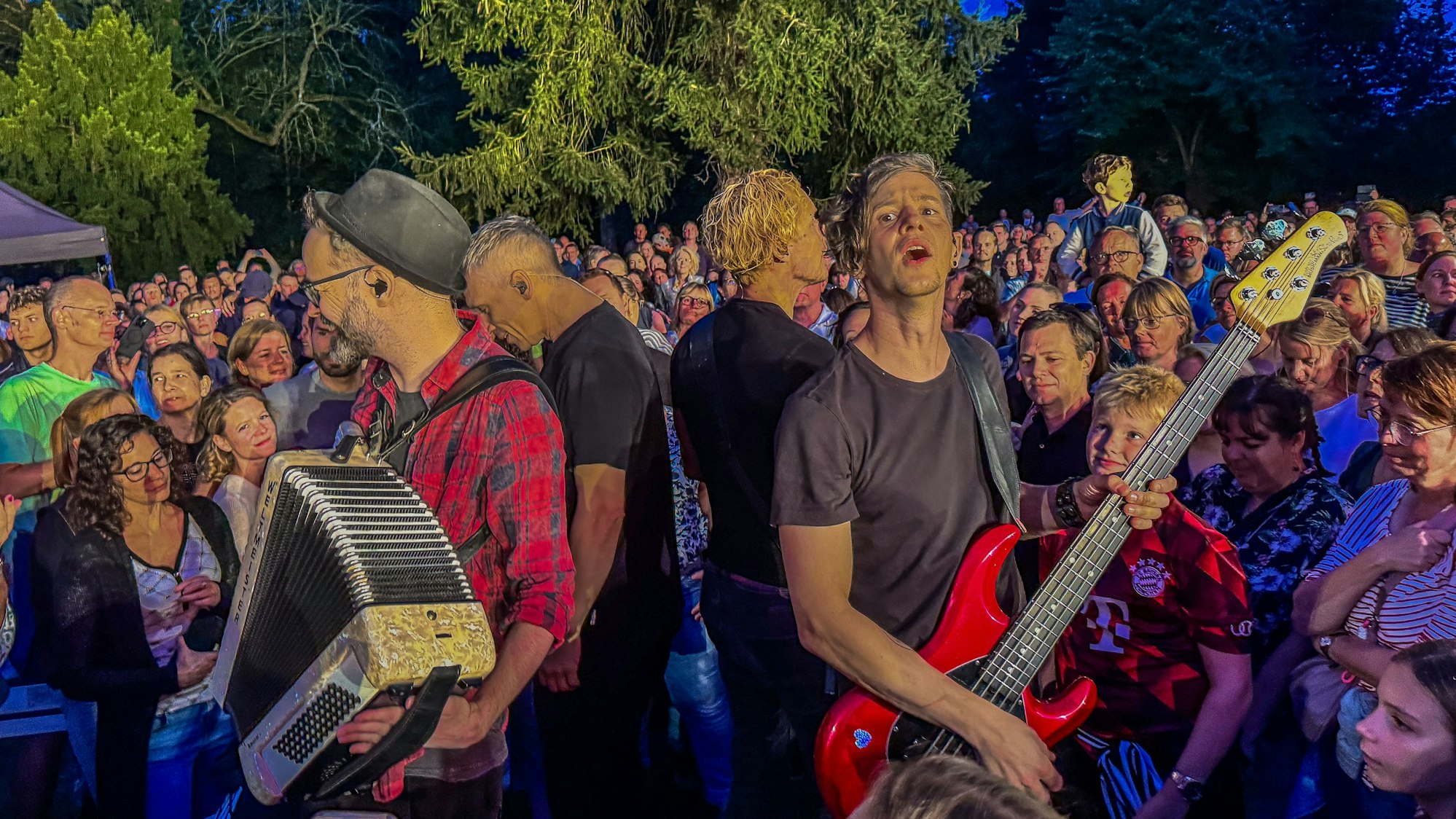 Musiker spielen umringt von Publikum.