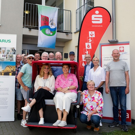 Eine Rikscha für Worringen. 
Bild: in der Rikscha: Raisat Simon (l.) Iwona Prewlic-Koch vom Lazarus Haus Blumenberg, rechts hockend: Silke Joseph, Elisabeth-von-Thüringen Haus Worringen, ganz rechts: Hartmut Emme Seniorennetzwerk Worringen, links daneben Susanne Schumacher, Kranken- und Pflegeverein Worringen, links neben ihr: Matthias Kklehr, Kreissparkasse Worringen, hinter der Rikscha rechts mit Kappe: Kaspar Dick, Vors. Bürgerverein Worringen, alle anderen sind Rikscha-Piloten