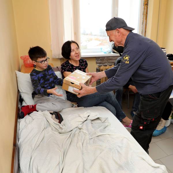 Norbert Kuhl von der Humanitären Hilfe Overath übergibt einem Kind in der Kindeklinik Lviv ein Geschenk.