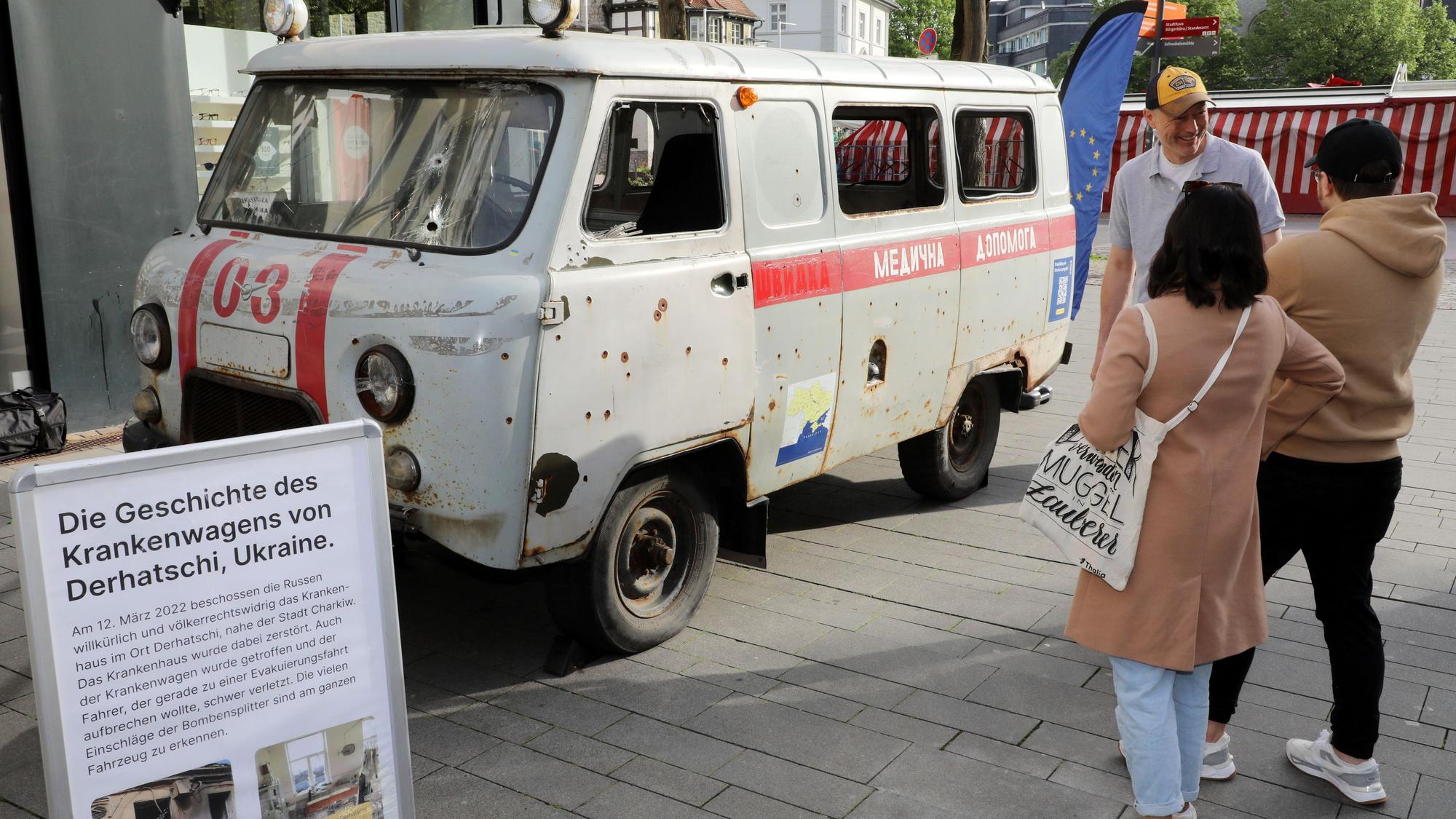 Mit einem zerschossenen ukrainischen Krankenwagen machen Mitglieder des Städtepartnerschaftsvereins Bergisch Gladbach – Butscha auf den Krieg in der Ukraine aufmerksam.
