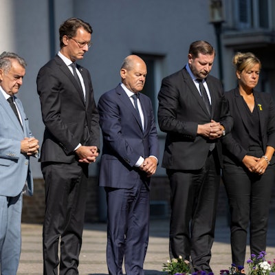 26.08.2024, Nordrhein-Westfalen, Solingen: Herbert Reul (CDU, l-r), Innenminister von Nordrhein-Westfalen, Hendrik Wüst (CDU), Ministerpräsident von Nordrhein-Westfalen, Bundeskanzler Olaf Scholz (SPD), Tim Kurzbach (SPD), Bürgermeister von Solingen, und Mona Neubaur (Grüne), stellvertretende Ministerpräsidentin von Nordrhein-Westfalen, stehen mit gefalteten Händen vor Blumen, die in Gedenken an die Opfer niedergelegt wurden. Bei einer Messerattacke auf der 650-Jahr-Feier der Stadt Solingen am 23. August hatte es drei Todesopfer und Verletzte gegeben. Foto: Thomas Banneyer/dpa +++ dpa-Bildfunk +++