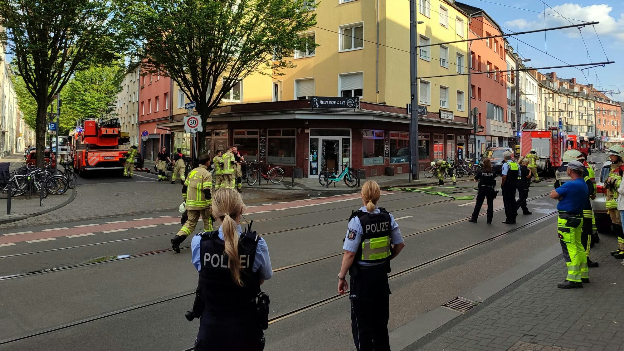 Einsatzkräfte der Feuerwehr und Polizei am Ort des Brandes in Köln-Zollstock.