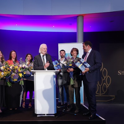 Vertreter des Vereins Blau-Gelbes Kreuz nehmen auf einer Bühne den Altstadtpreis entgegen