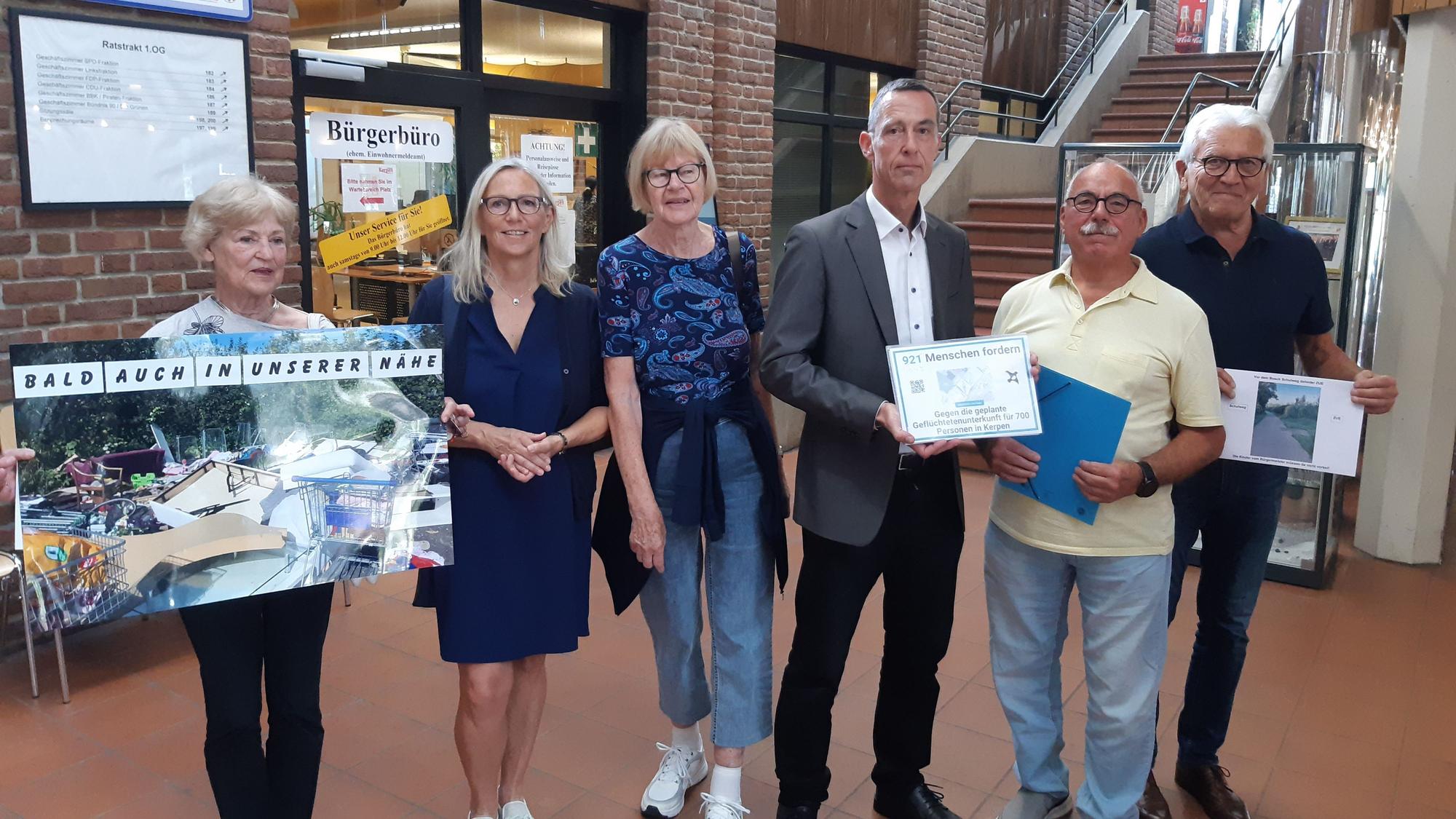 Auf dem Bild sind einige besorgte Bürgerinnen und Bürger zu sehen, die ihre Petition dem Kerpener Bürgermeister Dieter Spürck übergeben.