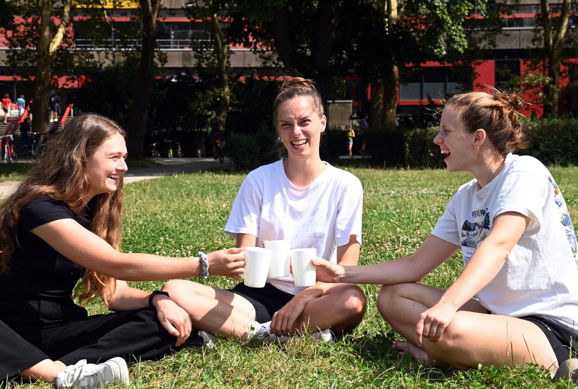 26.08.2024 Köln. V.Li.: Lina, Nora und Henni sitzen auf einer Wiese im Uni-Viertel.