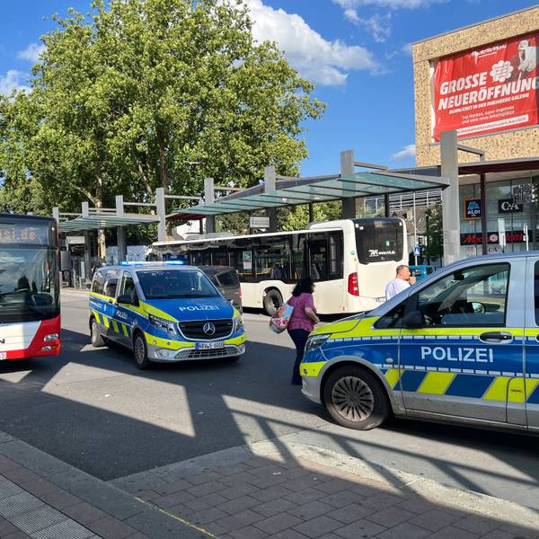 Zwei Polizeifahrzeuge mit eingeschaltetem Blaulicht stehen auf dem Bergisch Gladbacher Busbahnhof