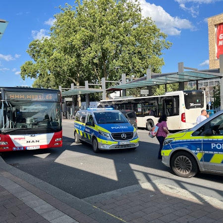 Zwei Polizeifahrzeuge mit eingeschaltetem Blaulicht stehen auf dem Bergisch Gladbacher Busbahnhof