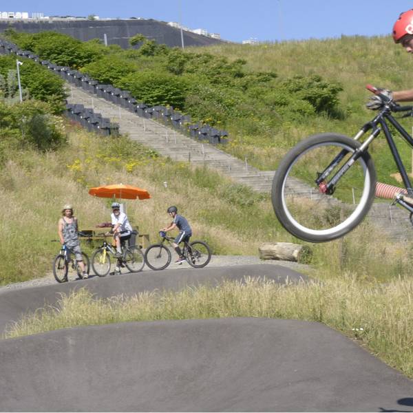 Ein Fahrradfahrer fliegt über eine Asphaltpiste.