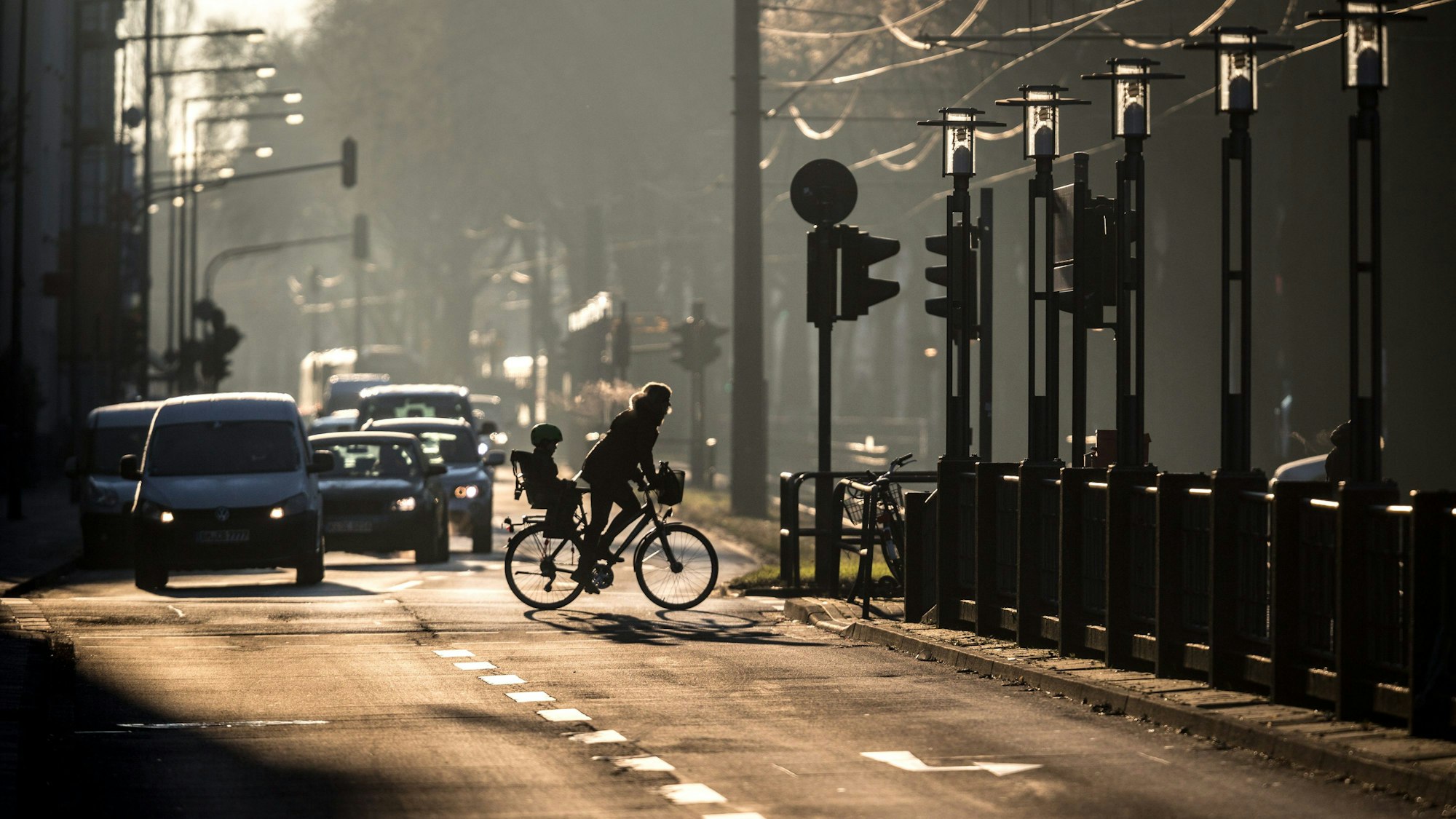 Eine Fahrradfahrerin mit Kindersitz ist am Mittwochmorgen (18.01.2017) auf dem Sülzgürtel in Köln unterwegs. Die Temperaturen liegen an diesem sehr kalten Wintermorgen im Minusbereich.
