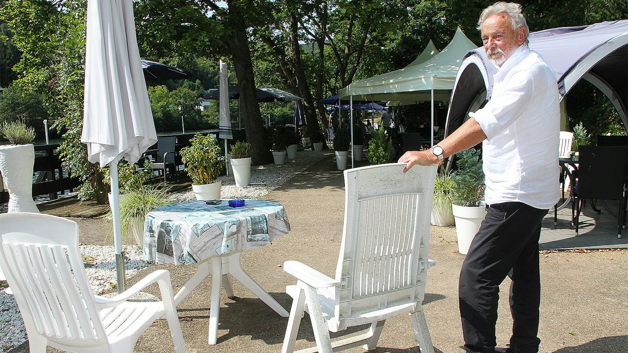 Franz Pütz steht neben einem Gartenstuhl.