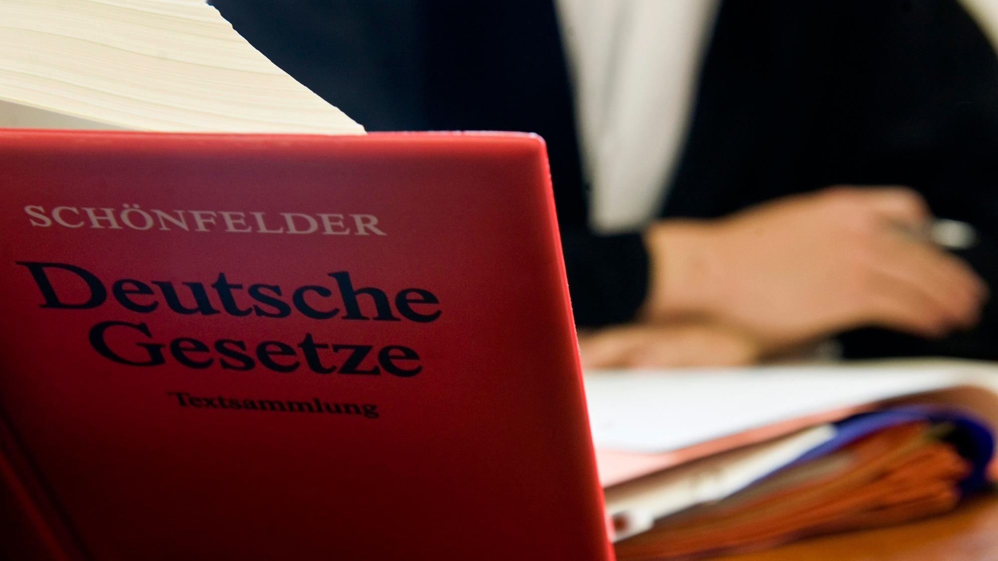 Ein Anwalt sitzt hinter der aufgeschlagenen «Schönfelder Textsammlung Deutsche Gesetze» im Amtsgericht.
