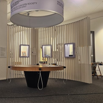 Ein runder Stehtisch mit Hörstationen.