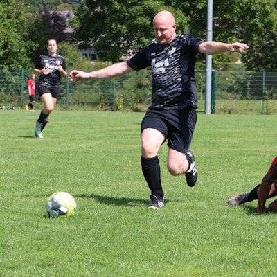 Das Bild zeigt Ingo Pfennings als Spieler der SpVg Nöthen-Pesch-Harzheim III und einen Akteur der TuS Mechernich, der auf dem Boden liegt.