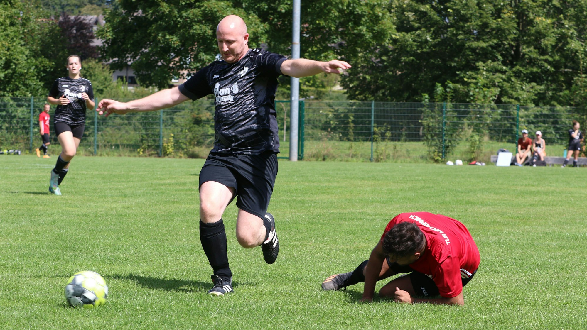 Das Bild zeigt Ingo Pfennings als Spieler der SpVg Nöthen-Pesch-Harzheim III und einen Akteur der TuS Mechernich, der auf dem Boden liegt.