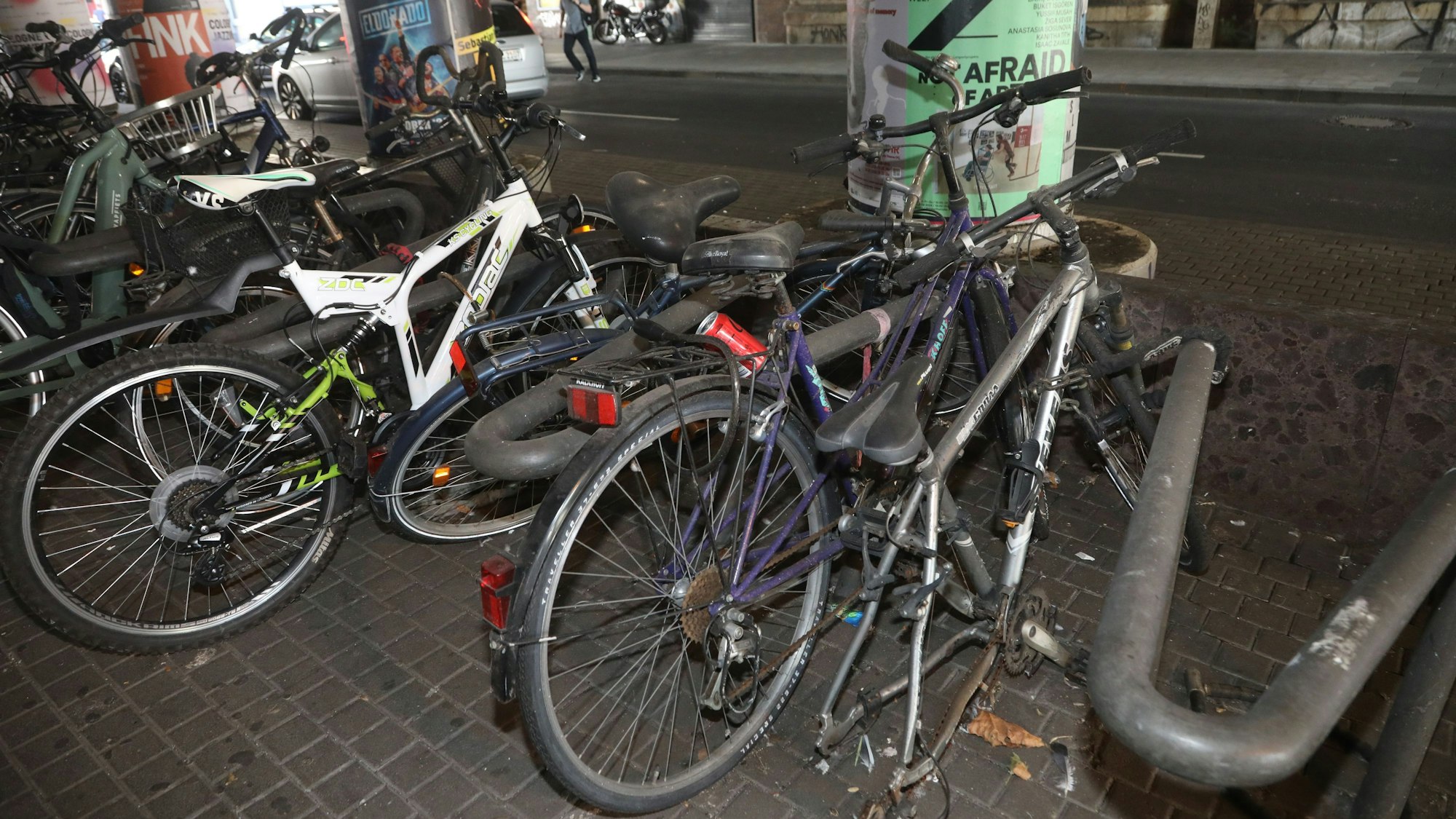 Kaputte Räder in verschmierten Fahrradständern.