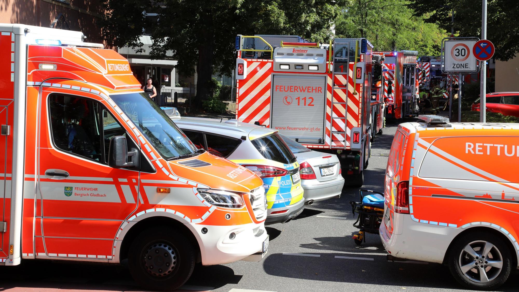 Rettungswagen und Feuerwehrfahrzeug stehen in Bergisch Gladbach-Heidkamp vor dem Berufskolleg Kaufmännische Schulen.