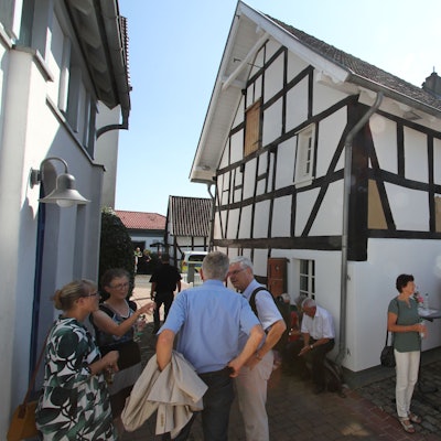 Menschen vor einem Fachwerkhaus
