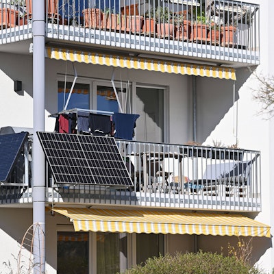 Balkonkraftwerk und Photovoltaikanlage, Solarpanele an der Außenseite eines Balkons von einem Wohnblock in München.
