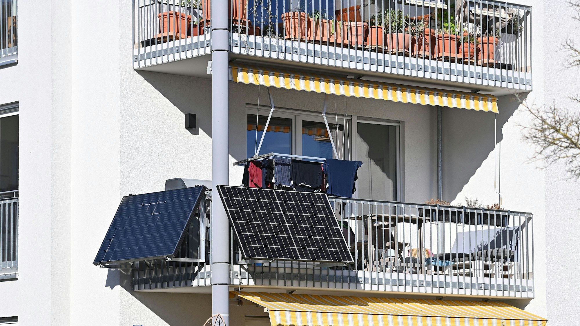 Balkonkraftwerk und Photovoltaikanlage, Solarpanele an der Außenseite eines Balkons von einem Wohnblock in München.