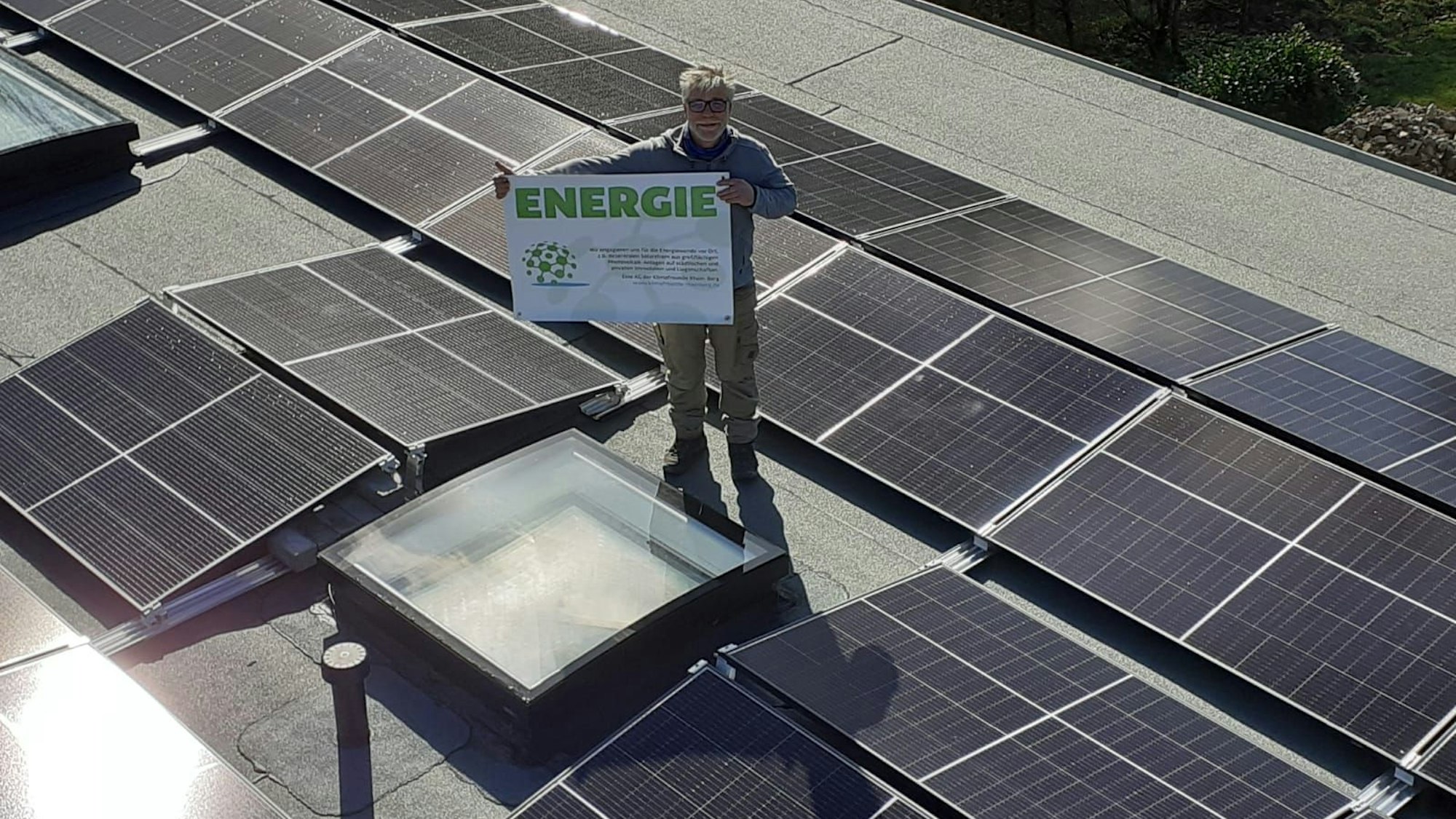 Stefan Häusler, Vorsitzender Klimafreunde Rhein-Berg, Steht auf einem Dach mit PV-Anlagen.