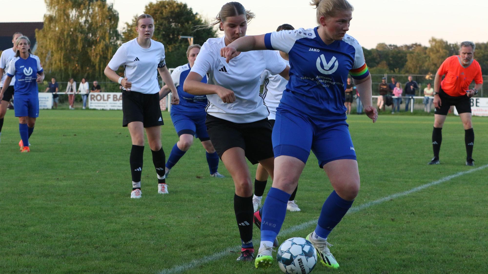 Erfthöhens Spielerin schirmt den Ball gegen eine Kommerner Gegenspielerin ab. Der Schiedsrichter schaut ganz genau hin, ob alles mit rechten Dingen zugeht.
