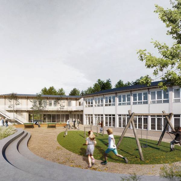 Kinder laufen über einen Spielplatz, im Hintergrund ein Haus aus zwei Baukörpern.