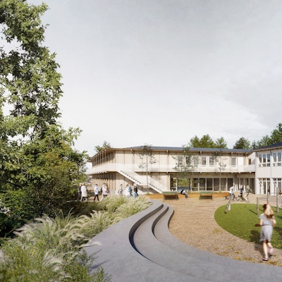 Kinder laufen über einen Spielplatz, im Hintergrund ein Haus aus zwei Baukörpern.