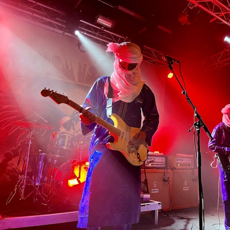 Der nigrische Gitarrist Mdou Moctar trägt auf der Bühne des Kölner Gebäudes 9 die Tagelmust genannte Turban-Gesichtsschleier-Kombination der Tuareg.