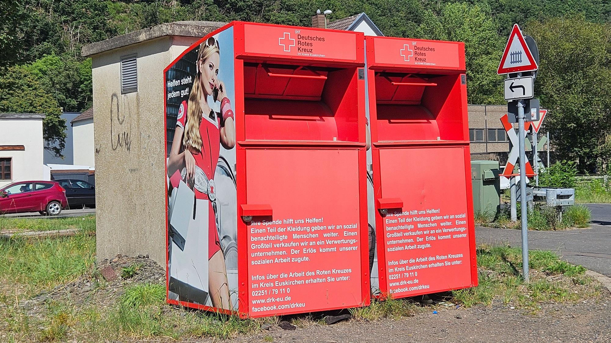 Blick auf zwei rote Altkleider-Sammelcontainer.