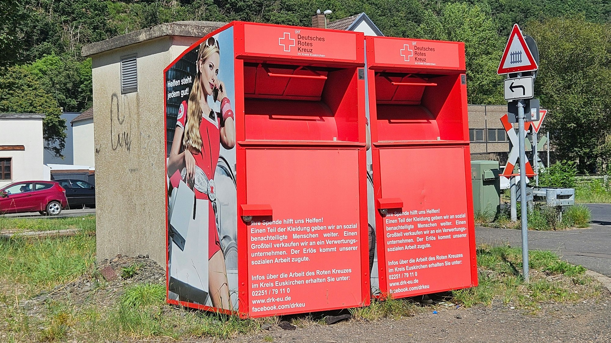 Blick auf zwei rote Altkleider-Sammelcontainer.