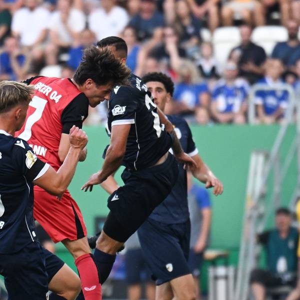 28.08.2024, Thüringen, Jena: Fußball: DFB-Pokal, FC Carl Zeiss Jena - Bayer 04 Leverkusen, 1. Runde, Ernst-Abbe-Sportfeld. Leverkusens Jonas Hofmann (M) setzt sich gegen Jenas Spieler Paul Krämer (l) und Justin Schau durch und erzielt den Treffer zum 0:1. Foto: Hendrik Schmidt/dpa - WICHTIGER HINWEIS: Gemäß den Vorgaben der DFL Deutsche Fußball Liga bzw. des DFB Deutscher Fußball-Bund ist es untersagt, in dem Stadion und/oder vom Spiel angefertigte Fotoaufnahmen in Form von Sequenzbildern und/oder videoähnlichen Fotostrecken zu verwerten bzw. verwerten zu lassen. +++ dpa-Bildfunk +++